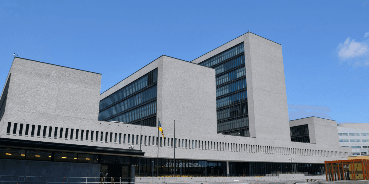 Modern architectural building with large glass windows against a clear blue sky