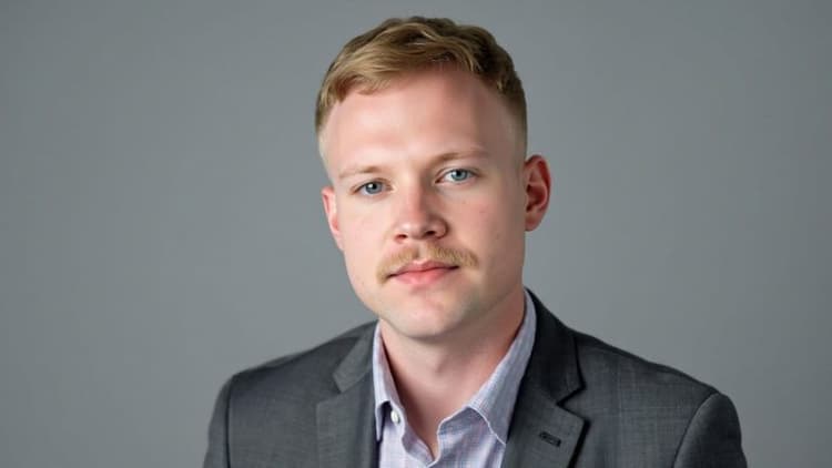 Portrait of author and ministry leader Alexander Hall wearing a gray blazer against a neutral gray background.