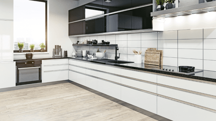 The kitchen features sleek modern design with custom cabinetry, a window with greenery view, and high-quality materials for a functional, stylish space.