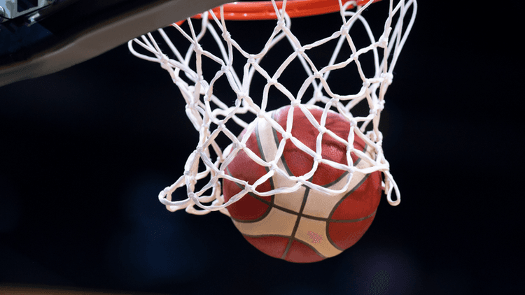 Basketball passing through the net during a game.