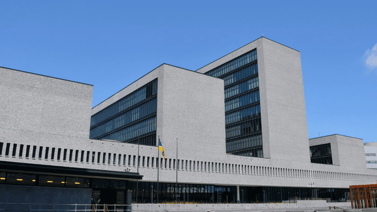 Modern architectural building with large glass windows against a clear blue sky
