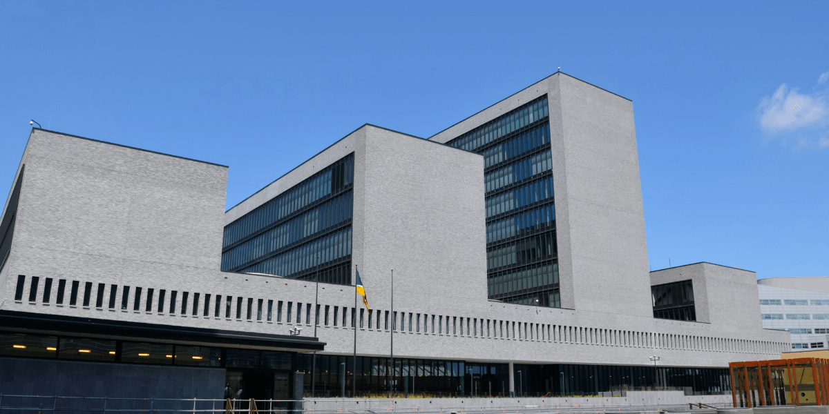 Modern architectural building with large glass windows against a clear blue sky