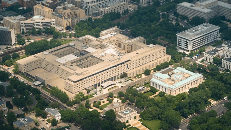 Aerial view of a large government building surrounded by greenery and urban structures