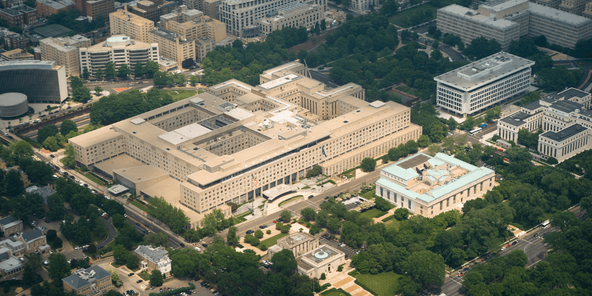 Aerial view of a large government building surrounded by greenery and urban structures