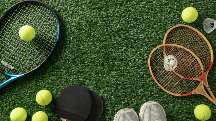 Tennis rackets, tennis balls, badminton rackets, and a shuttlecock on artificial grass