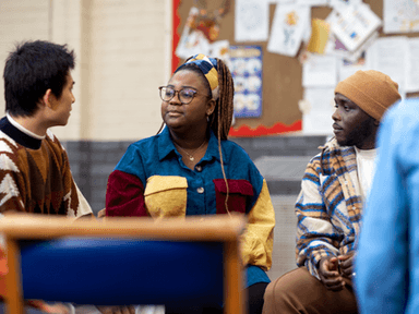A diverse group of young adults engaged in a discussion in a casual setting