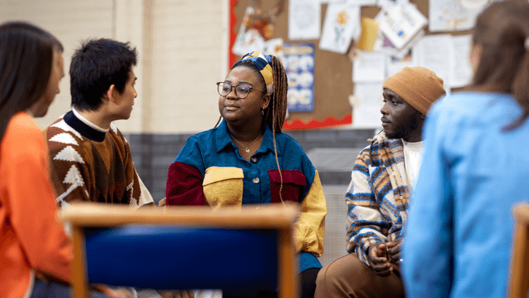 A diverse group of young adults engaged in a discussion in a casual setting
