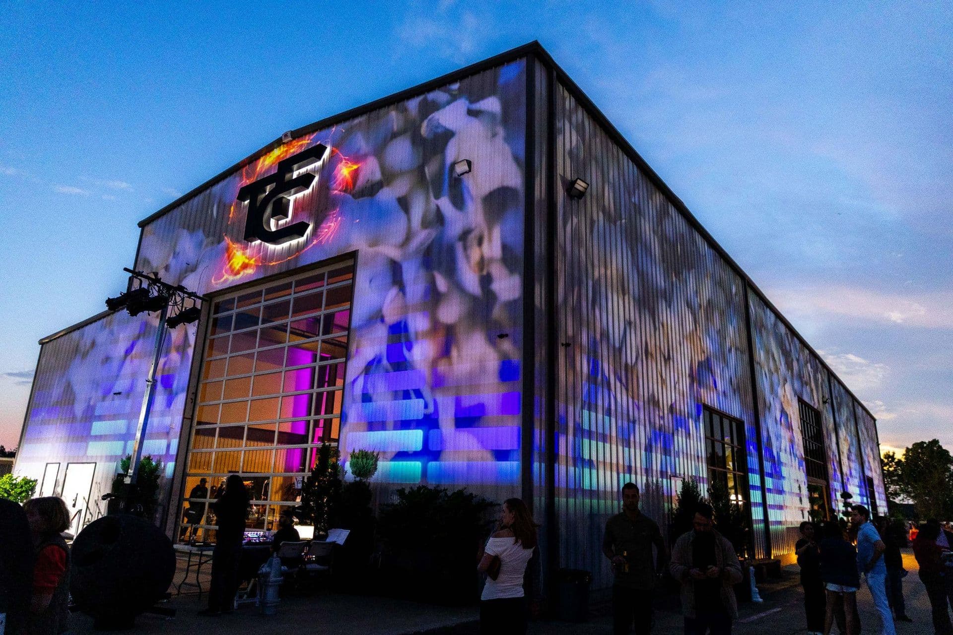Exterior of a building illuminated with colorful projections during an evening event.