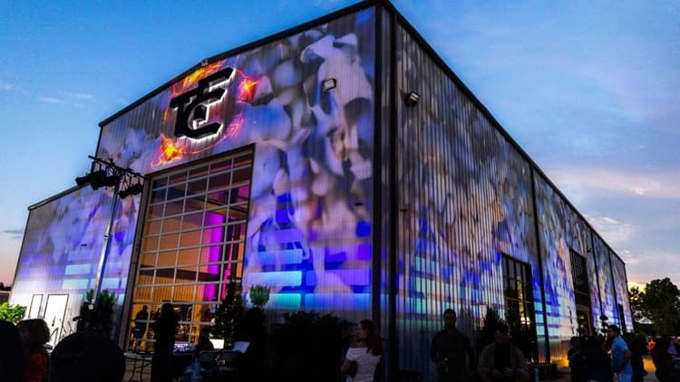 Exterior of a building illuminated with colorful projections during an evening event.