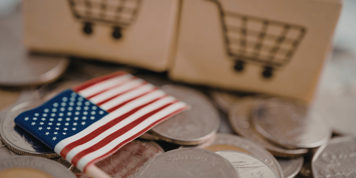Coins with a small American flag and shopping cart icons representing U.S. trade and commerce.